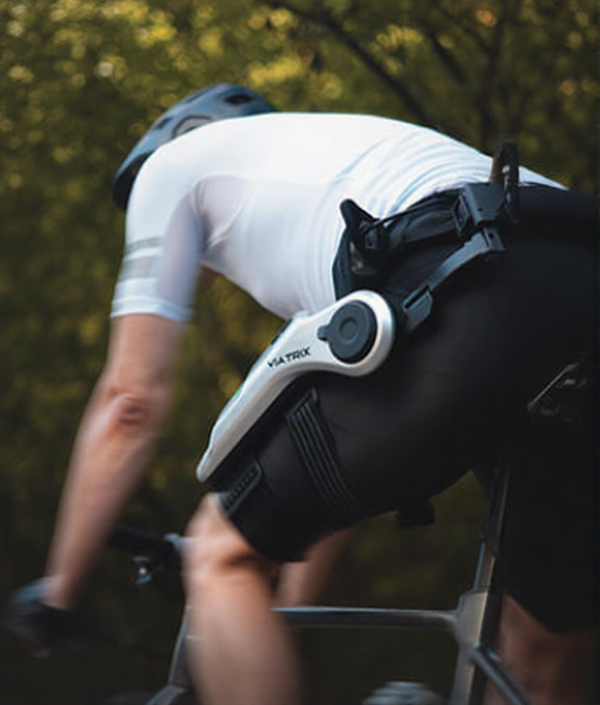 Cyclist wearing high-tech leg exoskeleton on outdoor bike ride